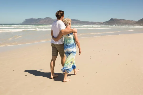 Kvinnan promenader med son på stranden — Stockfoto