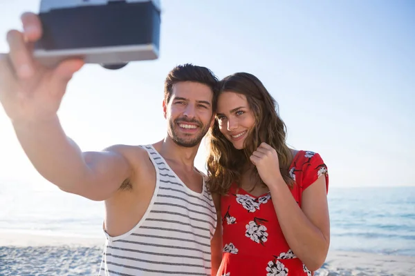 Joven pareja fotografiando a través de cámara — Foto de Stock