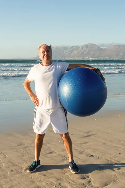 Hombre mayor sosteniendo pelota de ejercicio — Foto de Stock