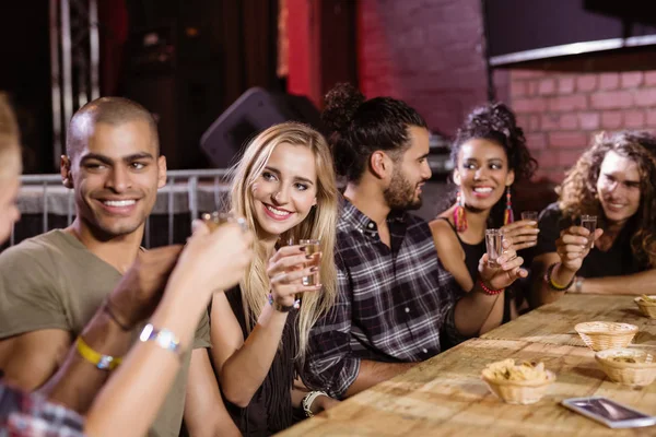 Vrienden praten zittend aan tafel — Stockfoto