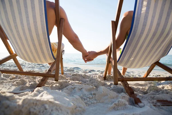 Пара держащихся за руки на пляже — стоковое фото