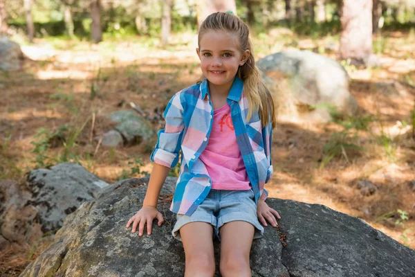 女孩坐在森林的石头上 — 图库照片