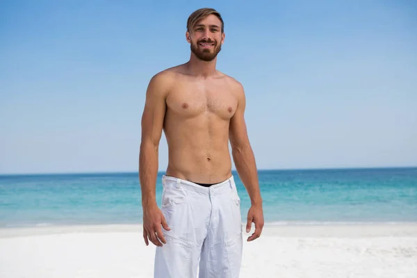 Homme torse nu souriant à la plage — Photo