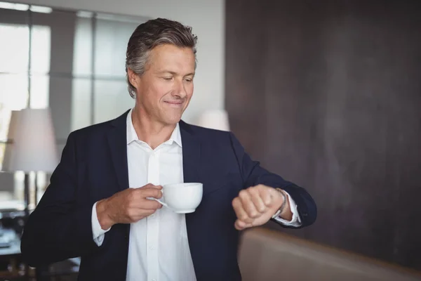 Hombre de negocios comprobar el tiempo mientras toma café —  Fotos de Stock