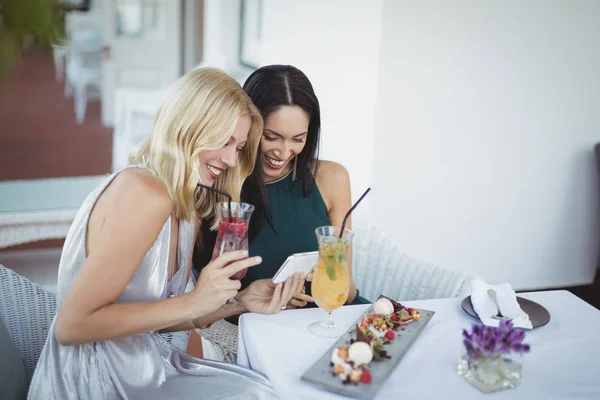 Smiling womens using mobile phone — Stock Photo, Image