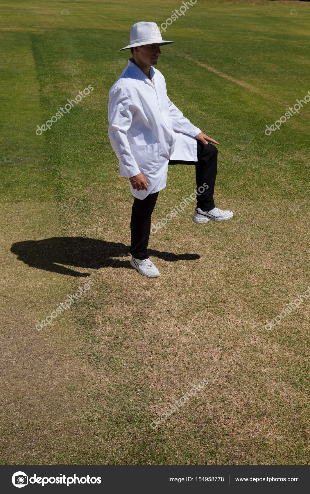 Cricket umpire signaling leg bye during match Stock Photo by