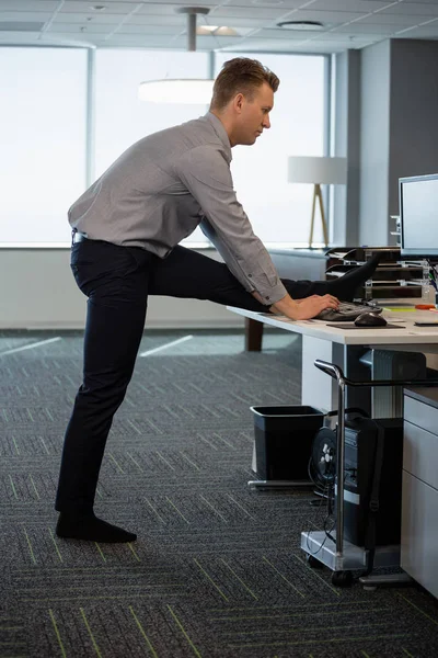 Executive performing stretching exercise at desk — Stock Photo, Image