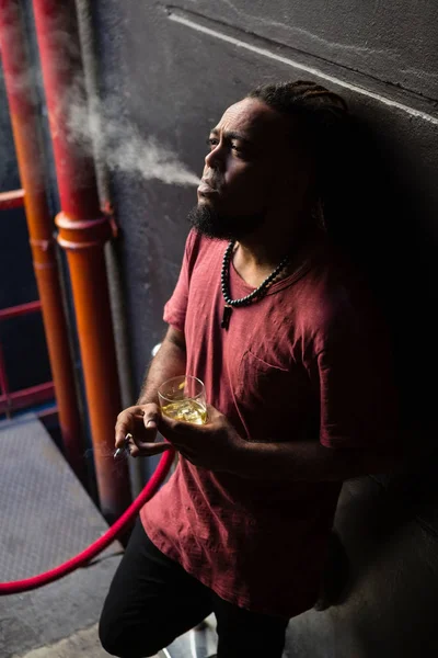 Hombre fumando mientras toma whisky — Foto de Stock