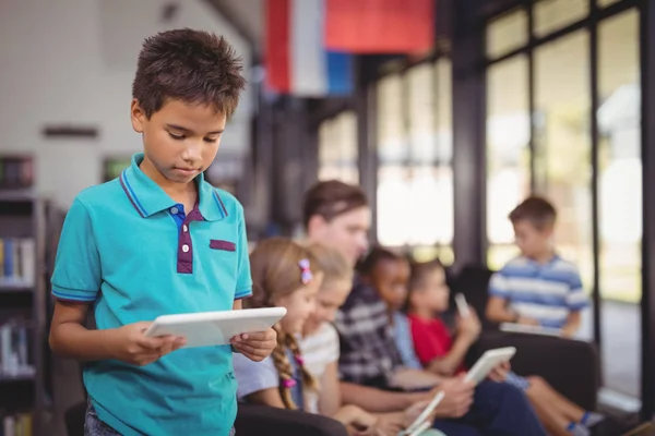 Attente schooljongen via tablet in bibliotheek — Stockfoto