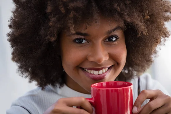 Femme aux cheveux crépus tenant une tasse de café — Photo