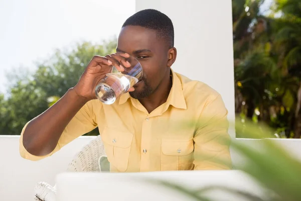 男はノート パソコンを見ながら水を飲む — ストック写真