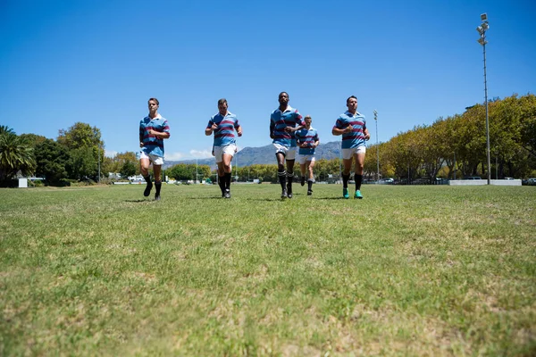 Equipe de rugby correndo em campo — Fotografia de Stock