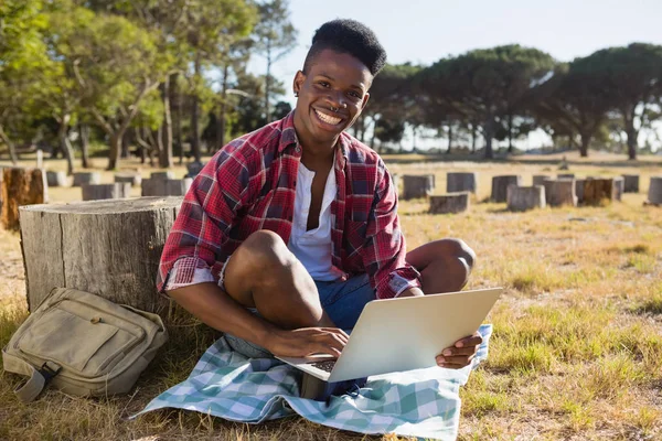 Uomo che utilizza il computer portatile nel parco — Foto Stock