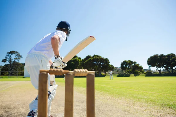 Cricketspiller som slår på banen – stockfoto