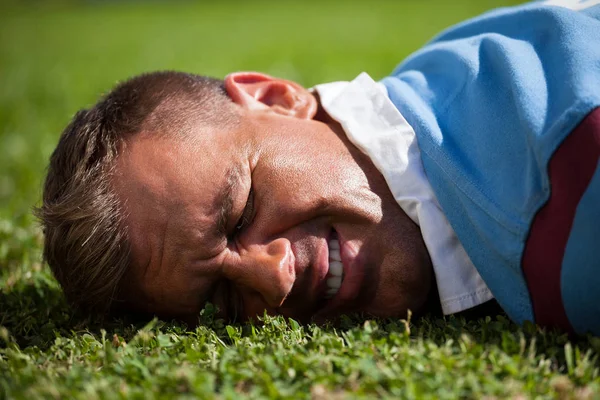 Jogador de rugby ferido deitado em campo — Fotografia de Stock