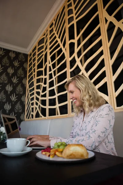 Empresaria usando laptop sentada en restaurante — Foto de Stock