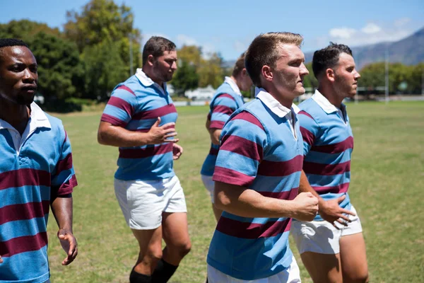 Rugbyteam joggen op gras veld — Stockfoto
