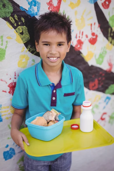 Gelukkig schooljongen houden maaltijd in lade — Stockfoto