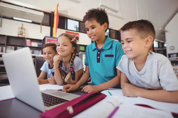 Schoolkinderen met laptop in de bibliotheek — Stockfoto