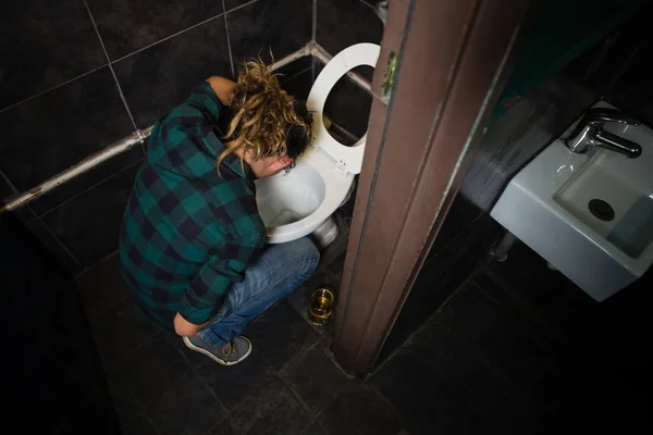 Hombre vomitando en inodoro — Foto de Stock