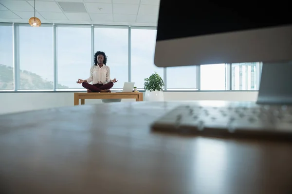 Женщина-руководитель медитирует на столе — стоковое фото