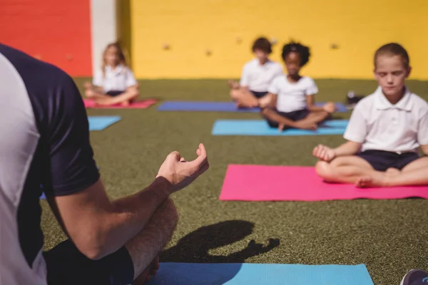 Entrenador y escolares practicando yoga — Foto de Stock