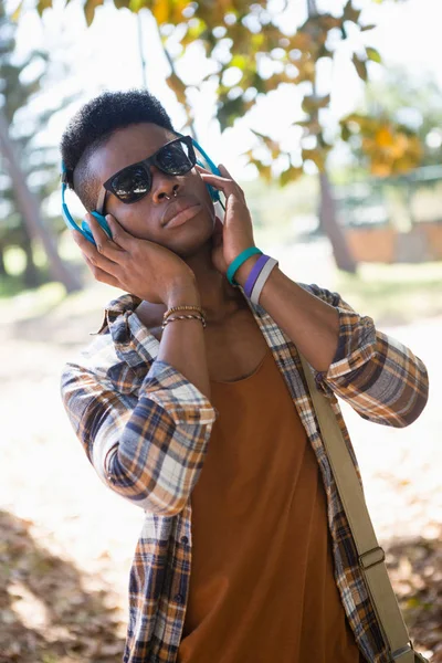Man in sunglasses and headphones listening to music — Stock Photo, Image