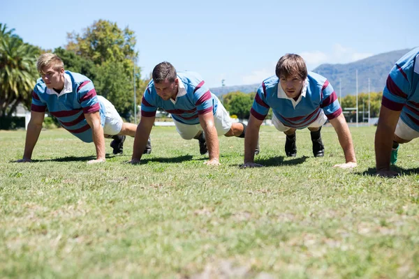 Graczy rugby robi push up — Zdjęcie stockowe