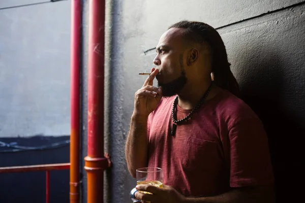 Hombre fumando mientras toma whisky — Foto de Stock