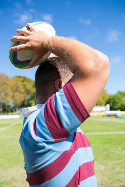 Игрок в регби бросает мяч на поле — стоковое фото