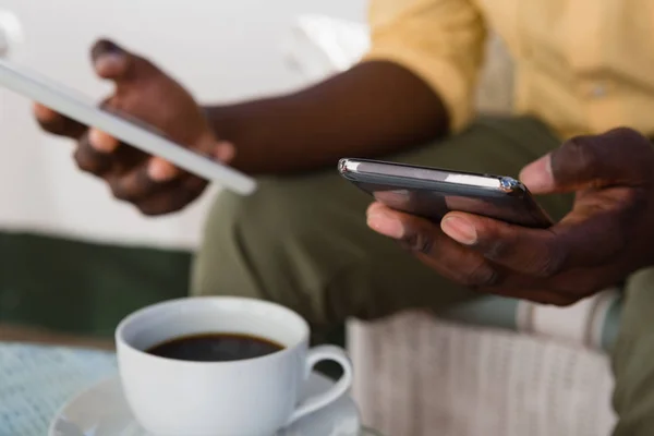 Uomo in possesso di cellulare e tablet — Foto Stock