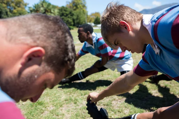 Rugby players stretching at field — Stock Photo, Image