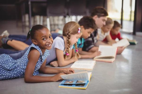 Öğretmen ve yerde yatarken schoolkids — Stok fotoğraf