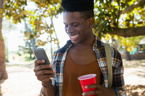 Uomo che utilizza il telefono cellulare nel parco — Foto Stock