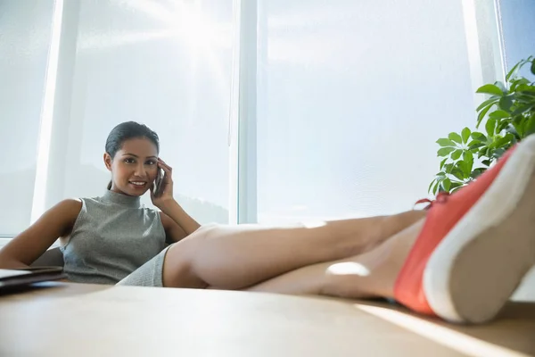 Manager entspannt sich am Schreibtisch beim Telefonieren — Stockfoto