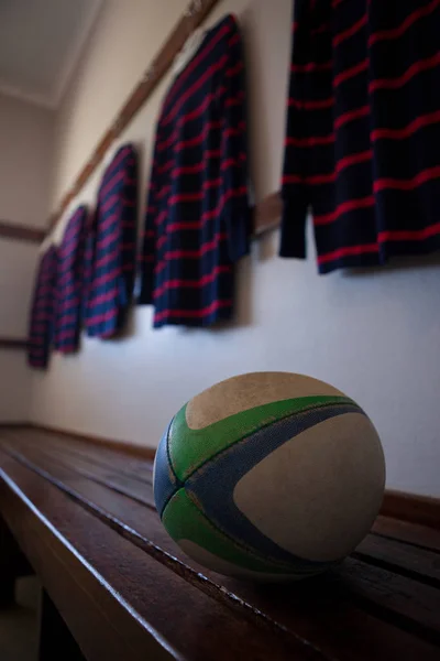 Rugby boll på bänk med t-shirts — Stockfoto