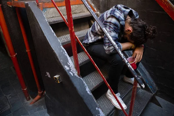 Пьяный мужчина сидит на лестнице — стоковое фото