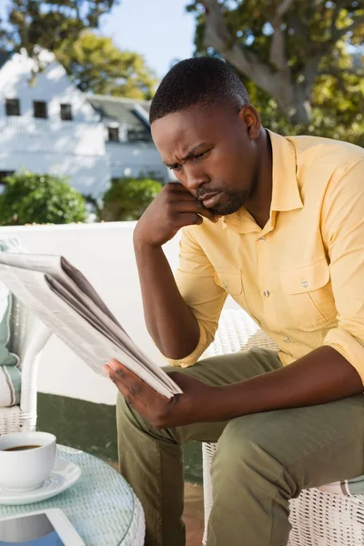 Hombre serio leyendo el periódico en la cafetería — Foto de Stock