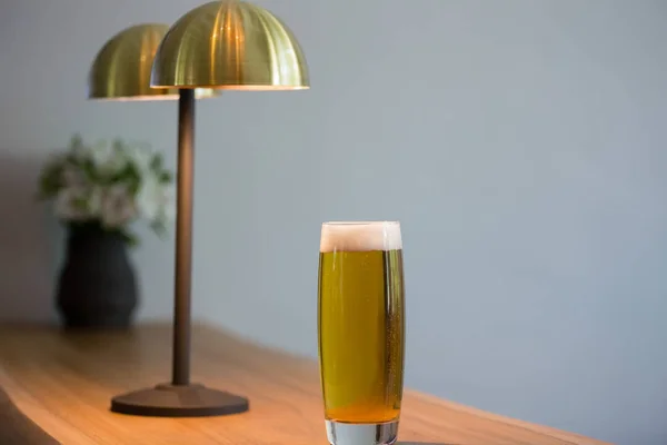 Bierglas door verlichtingsapparatuur in restaurant — Stockfoto