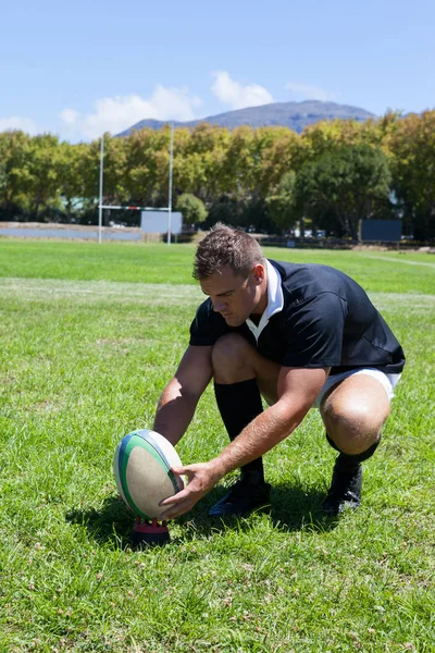 Jogador ajoelhado com bola de rugby — Fotografia de Stock