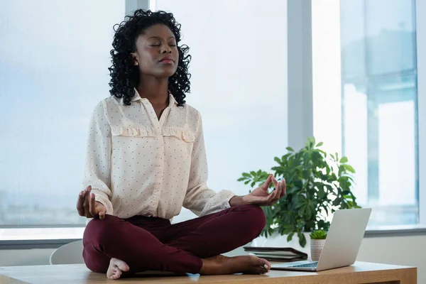 Mujer ejecutiva meditando en el escritorio —  Fotos de Stock