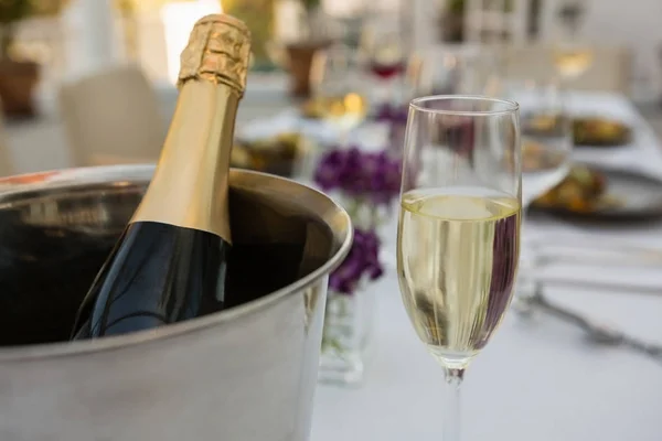 Champagnefles in emmer met glas — Stockfoto