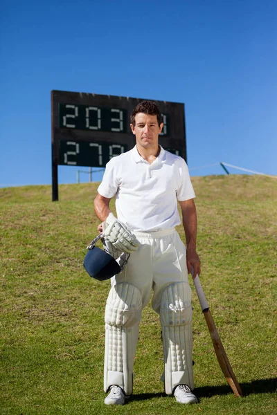 Cricket speler permanent tegen scorebord — Stockfoto