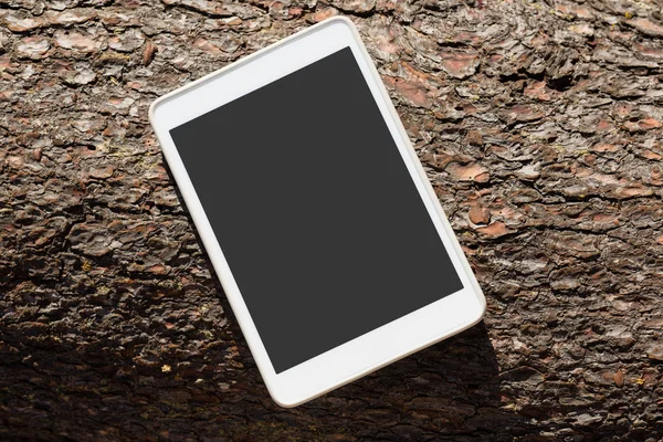 Digitales Tablet auf einem Baumstamm — Stockfoto