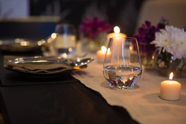 Dricksglas av tända ljus på matbordet — Stockfoto