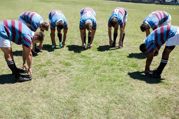 Jogadores de rugby curvando no campo gramado — Fotografia de Stock