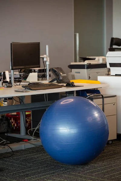 Fitness ball at desk — Stock Photo, Image