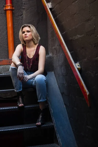 Eftertänksam kvinna sitter på trappan — Stockfoto