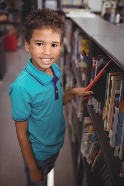 Школьник выбирает книгу в библиотеке — стоковое фото