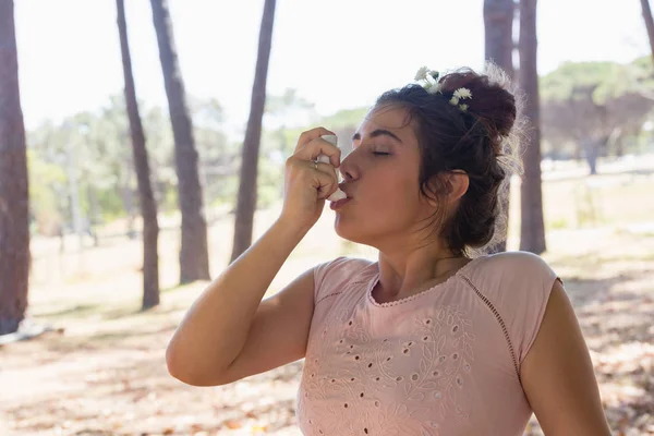 Femme utilisant un inhalateur d'asthme dans le parc — Photo